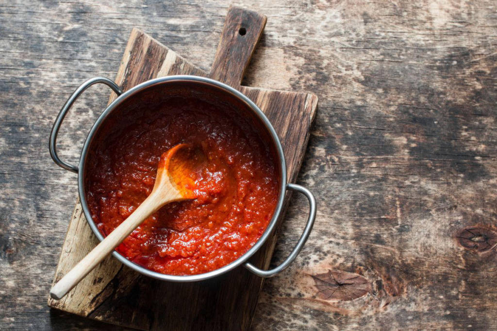 Step 6: In una padella soffriggete l’aglio in 3 cucchiai d’olio fino a quando non diviene dorato. Toglietelo e versate il pomodoro aggiungendo un pizzico di sale. Lasciate cuocere per 15-20 minuti.