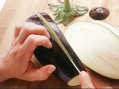 Step 1: La ricetta inizia con la preparazione delle melanzane, che vanno tagliate sottili in lunghezza e cosparse di sale grosso per evitare che rilascino liquidi durante la cottura. Lasciatele riposare per un’oretta poi risciacquare e asciugare